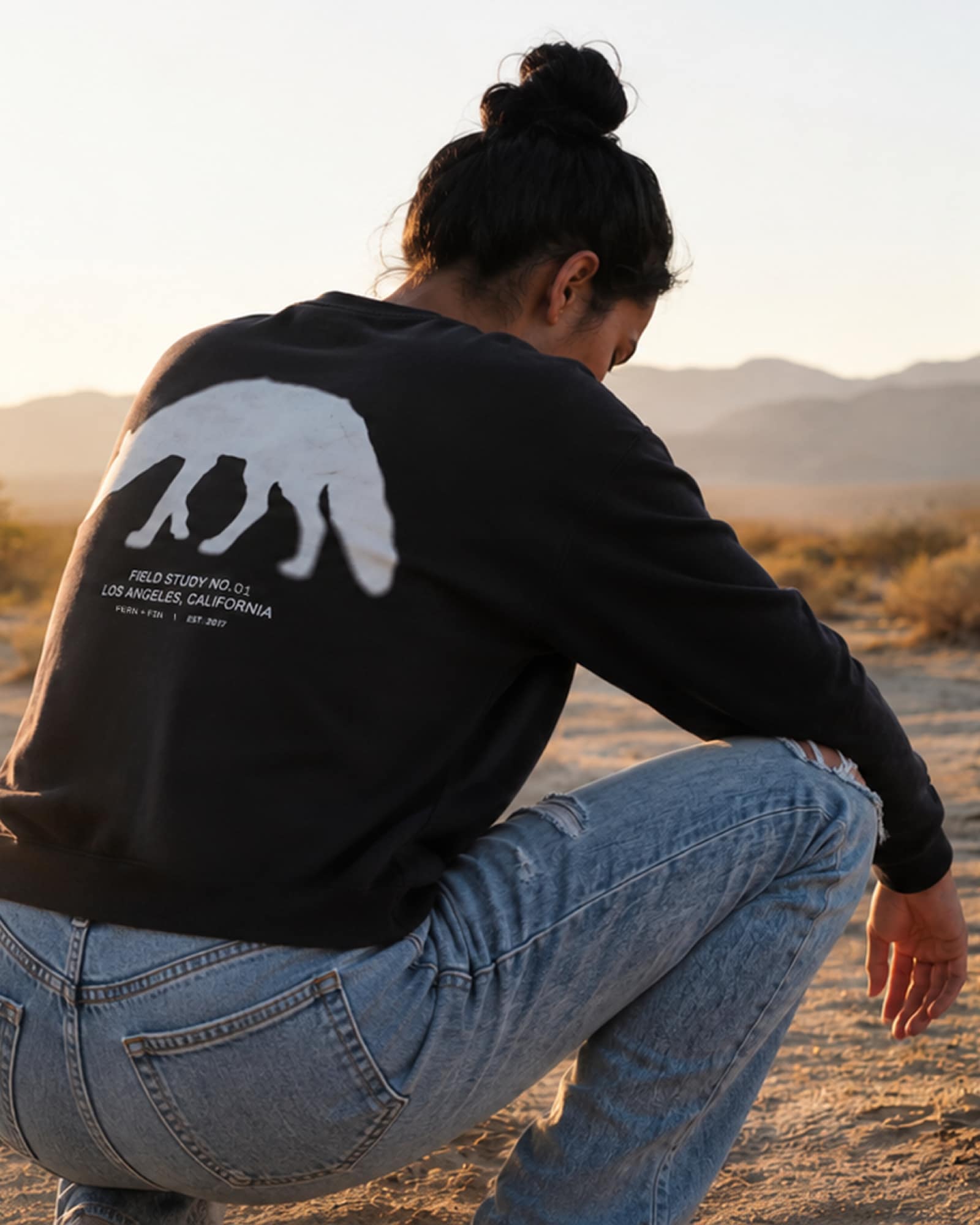 Mobile view of model wearing the FERN + FIN Field Study No. 01 sweatshirt on warm desert light.
